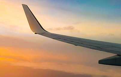 wing of a business jet against a dusky sky